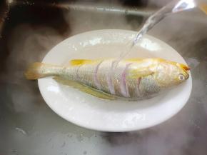 用开水冲一下黄鱼表面，去腥的同时，让鱼的花刀更加立体