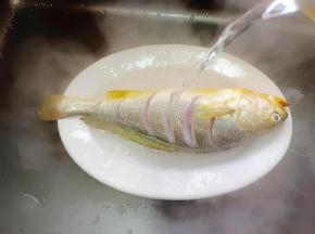 用开水冲一下黄鱼表面，去腥的同时，让鱼的花刀更加立体